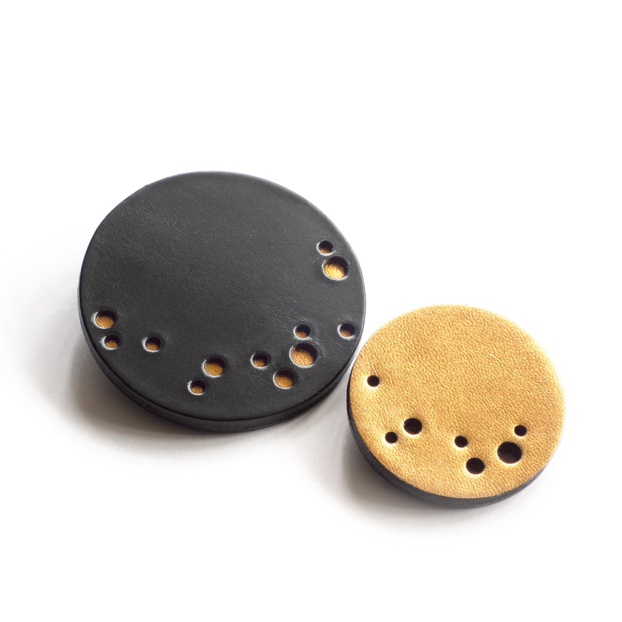 Broche ronde en cuir noir et doré perforé